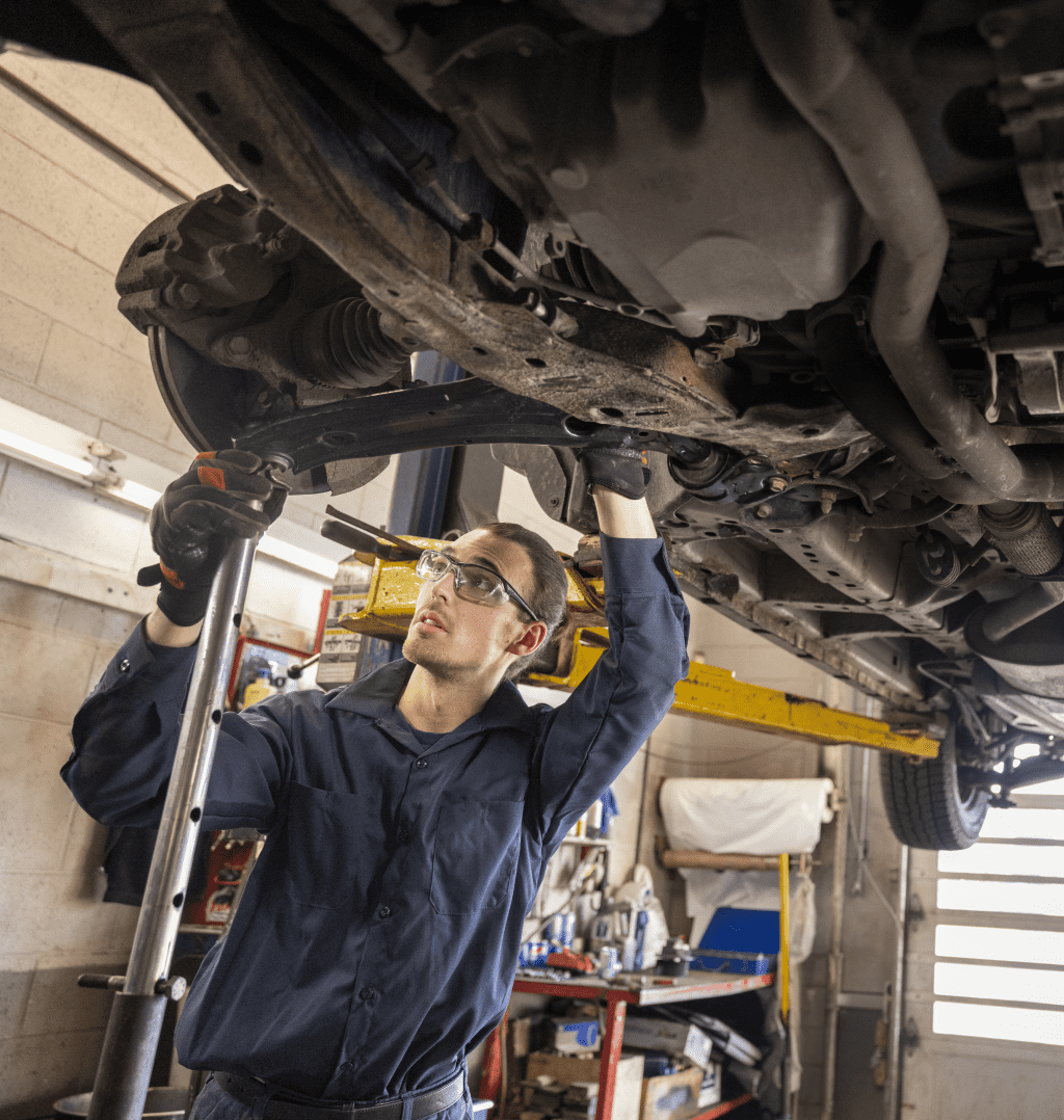 Mécanicien automobile dans son environnement de travail sous une voiture